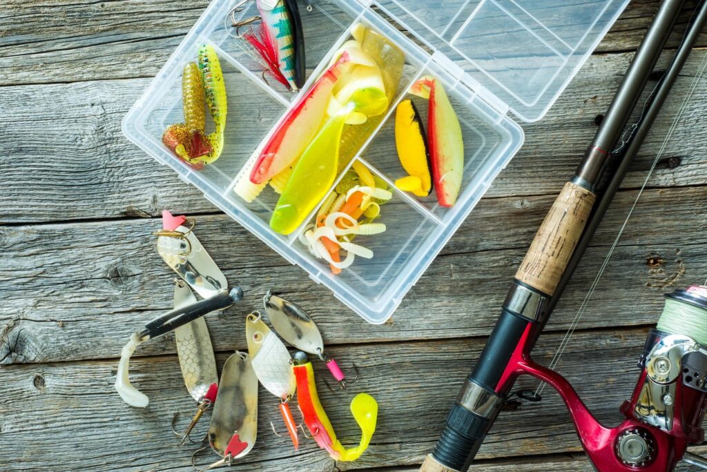 Assorted fishing tackle in a clear tackle box.